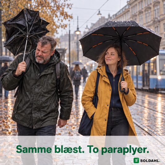 Mand med itu paraply og kvinde med Stormparaplyet på en blæsende gade i regn
