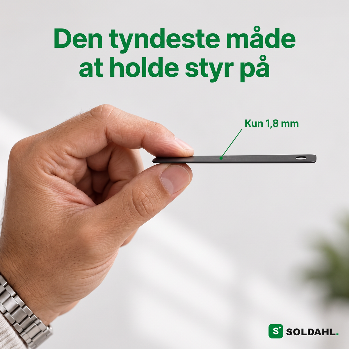 Hånd, der holder sporingskortet fra siden for at vise, at det kun er 1,8 mm tyndt